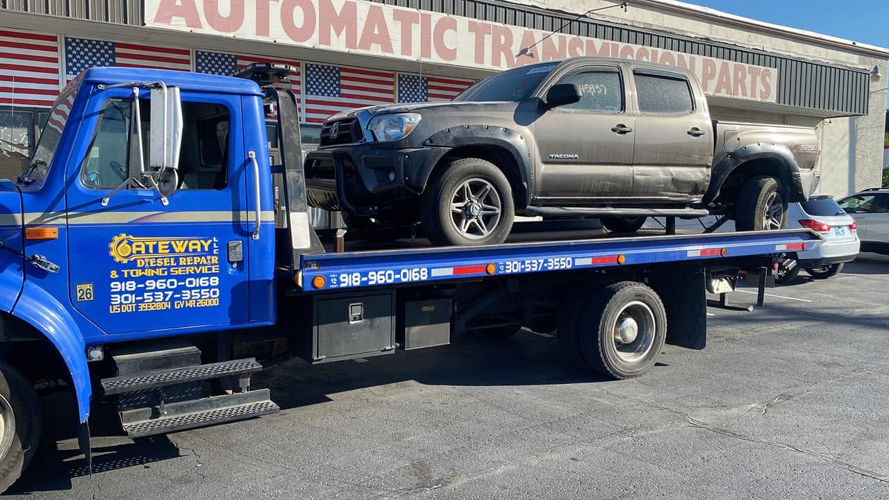 Flatbed tow truck recovering a diesel rig in Tulsa